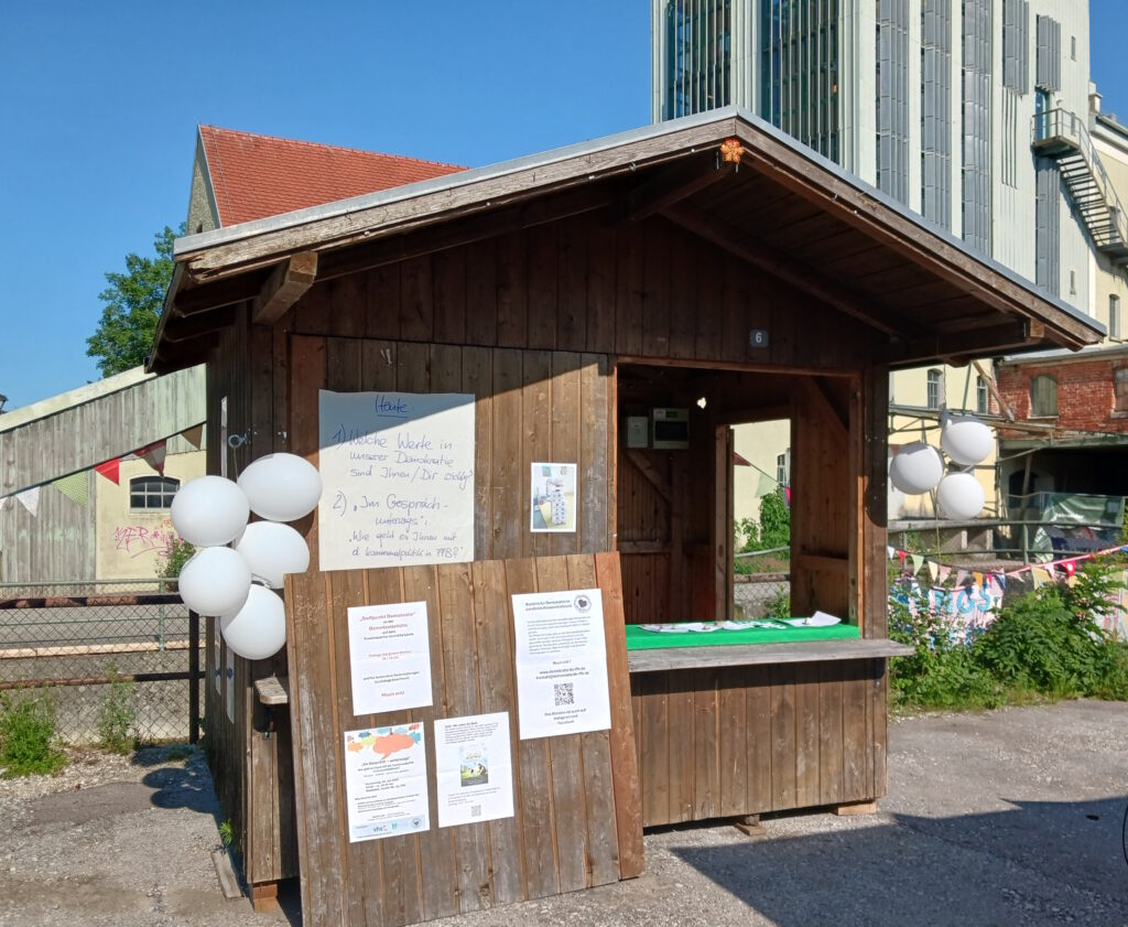 Eine Hütte mit Aushängen und Luftballons